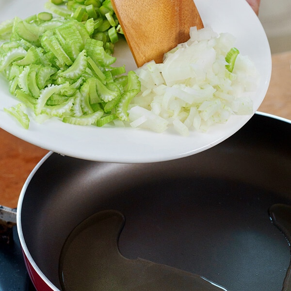 Làm nóng dầu trên chảo, cho hành tây và cần tây vào xào sơ với lửa nhỏ.